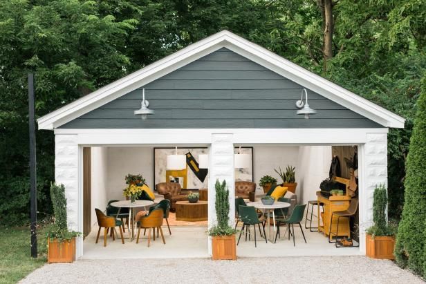 a white and gray shed with tables and chairs