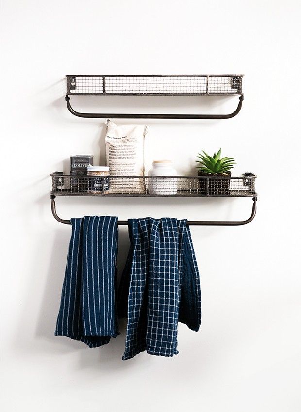 two metal shelfs with towels hanging on them and a potted plant in the corner