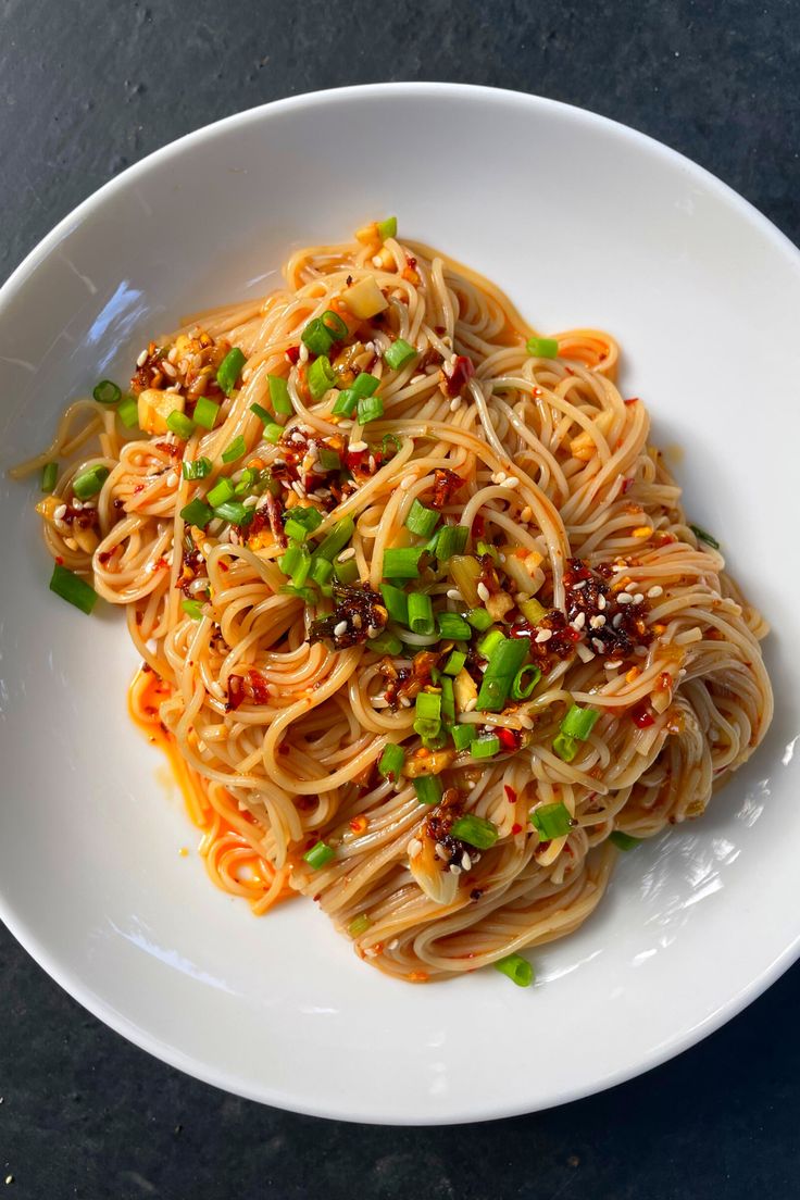 a white plate topped with noodles and vegetables