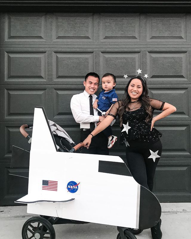 two adults and a child are posing in front of an airplane