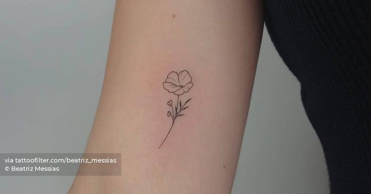 a small flower tattoo on the arm