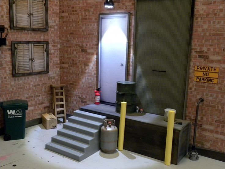 a set of stairs leading up to a brick building with a door and fire extinguisher next to it