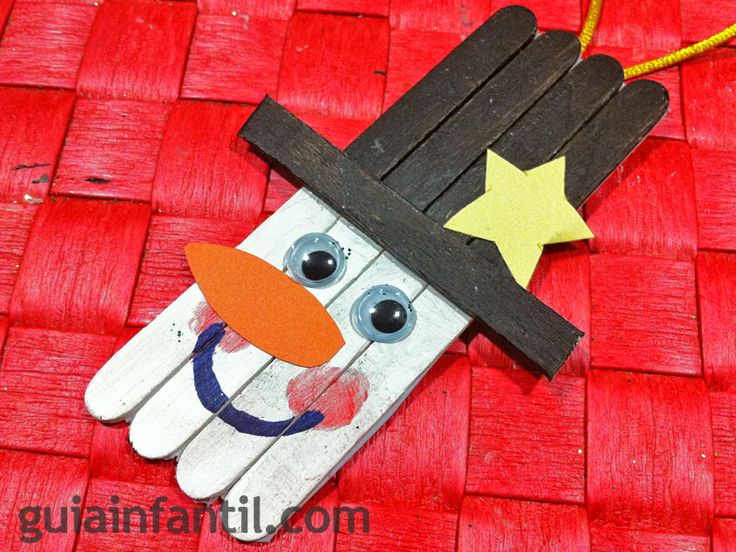 a hand made out of pops sticks with a snowman on it and a star hanging from the top