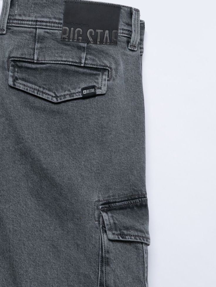 the back pocket of a pair of grey jeans with black stitching on the side