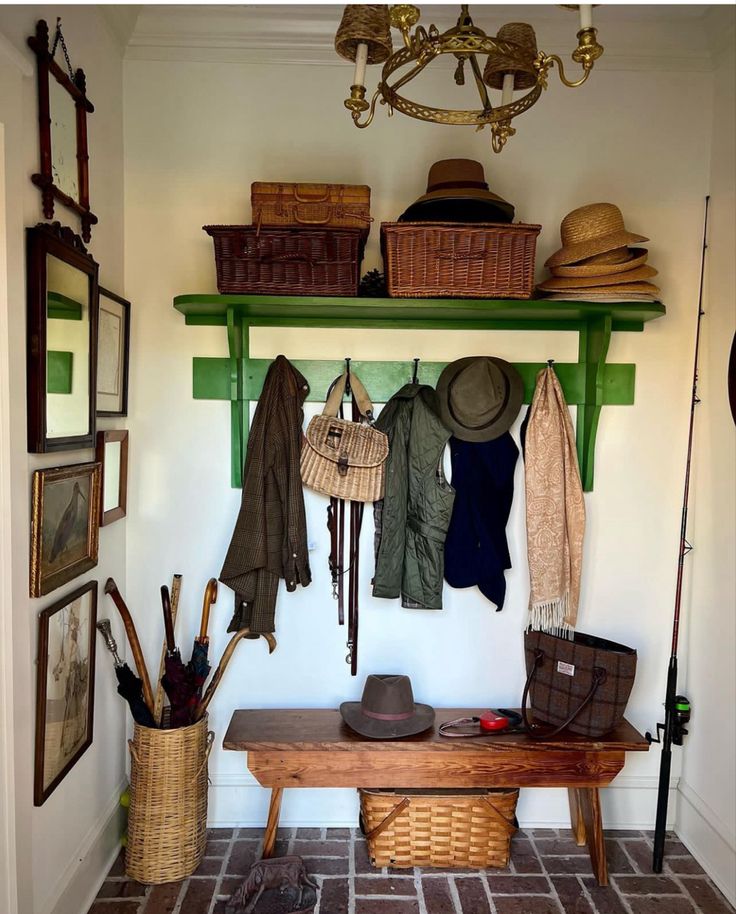 a bench with hats, umbrellas and other items hanging on the wall above it