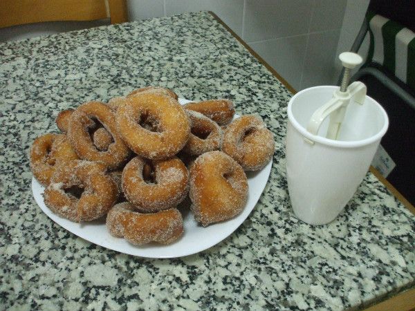 a plate full of donuts next to a cup of coffee on a counter top