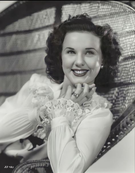 an old black and white photo of a woman smiling