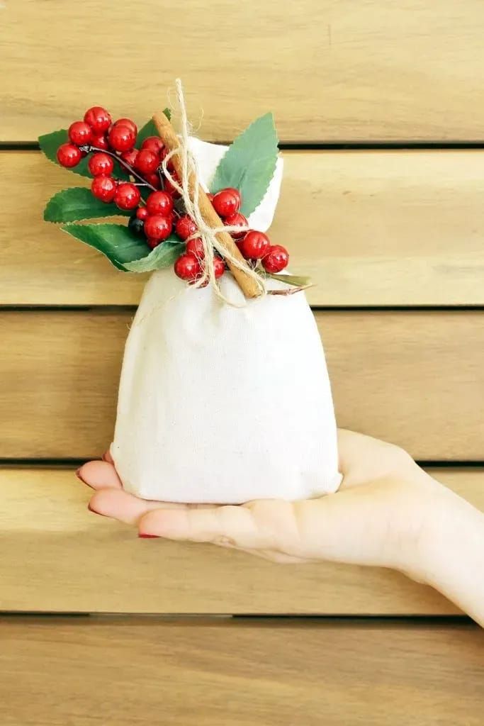 a hand holding a white bag with red berries on it and the words holiday cookie gift sack