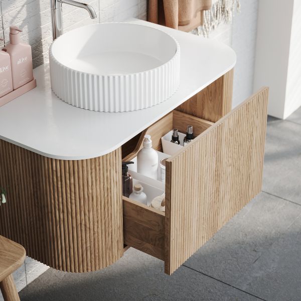 a white sink sitting under a bathroom mirror next to a wooden cabinet and counter top