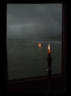 a candle is lit in front of a window