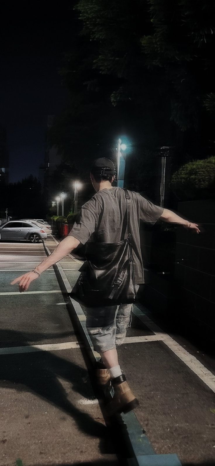 a man riding a skateboard down the side of a parking lot next to a street