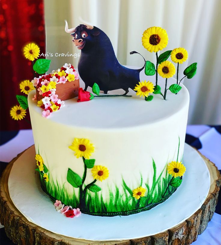 a cake decorated with an image of a bull and sunflowers is on a table