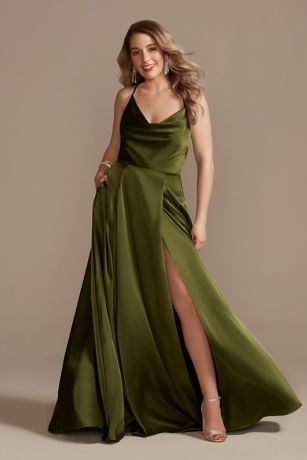 a woman in a long green dress posing for the camera with her legs slited