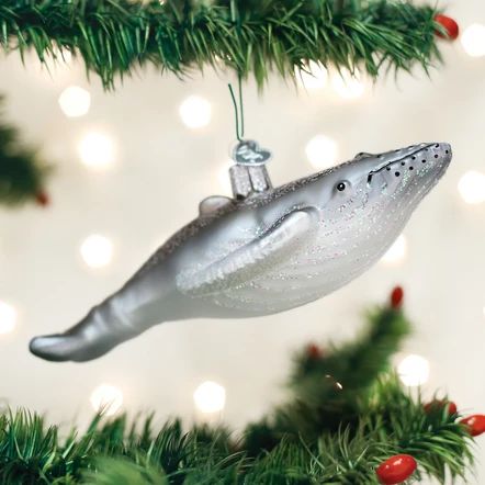 a silver ornament hanging from a christmas tree