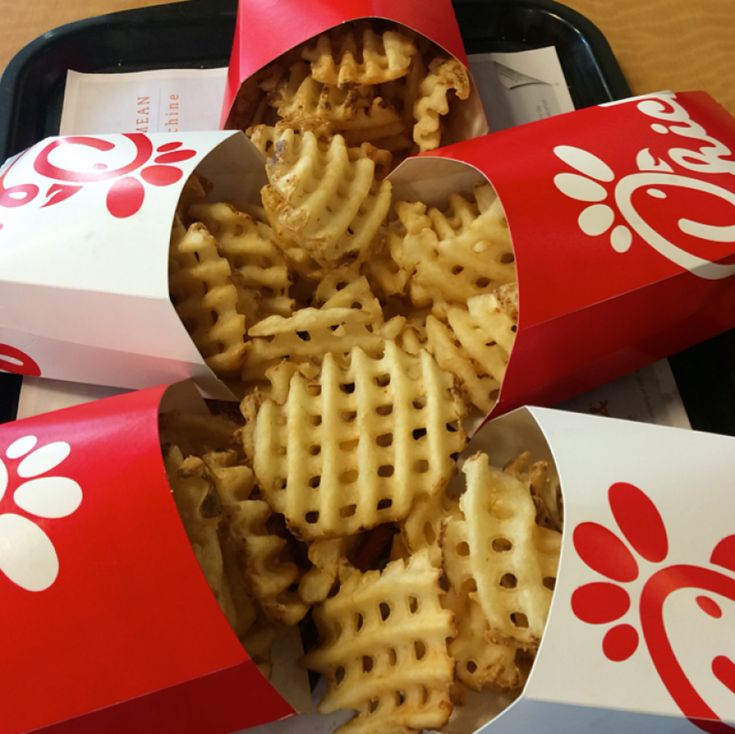 three red and white boxes filled with waffles sitting on top of a table