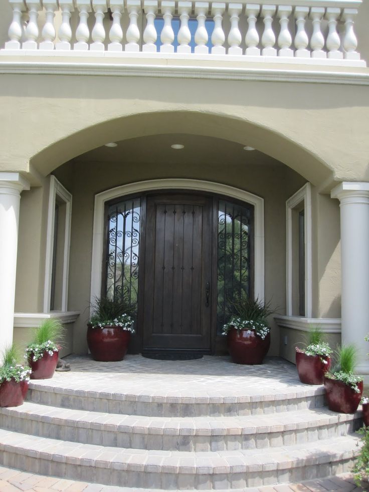 an entrance to a house with potted plants on the steps