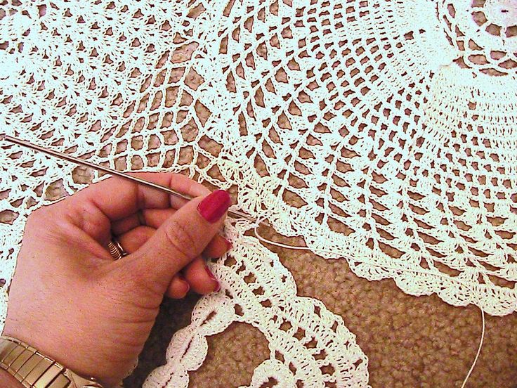 a woman is working with crochet on a doily