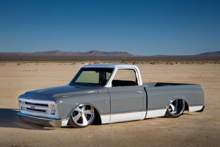 a gray truck parked on top of a dirt field