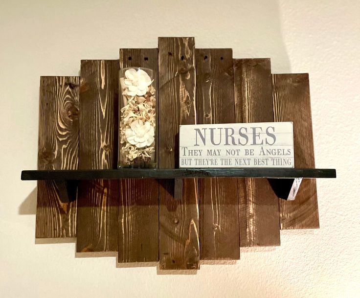 a wooden shelf with a sign that says nurses they may not be angels but there is only one thing