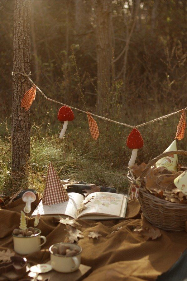 a picnic table with food and decorations in the woods