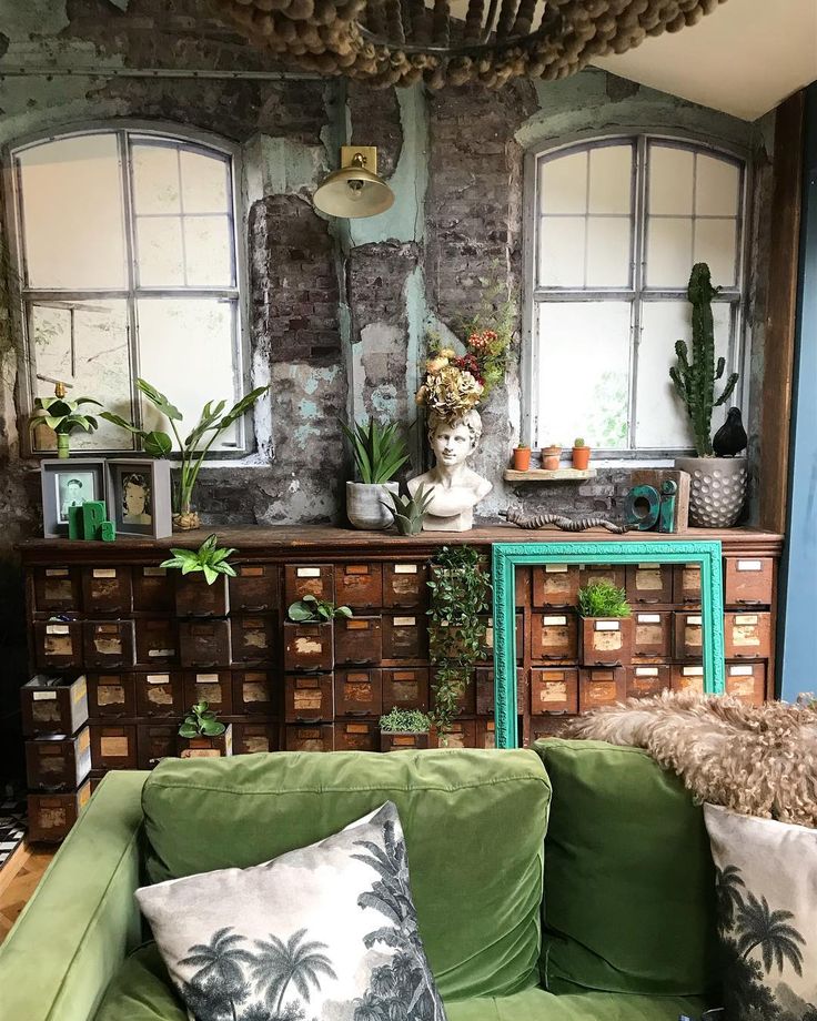 a living room filled with lots of furniture and plants on top of it's walls