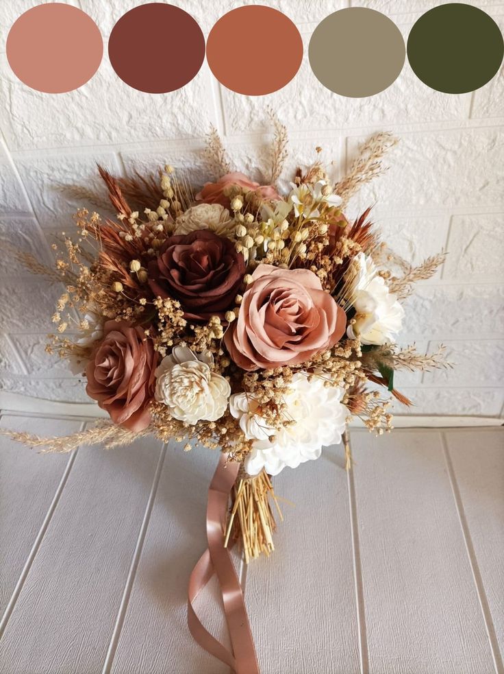 a bridal bouquet with flowers and foliage in shades of brown, pink, white and beige