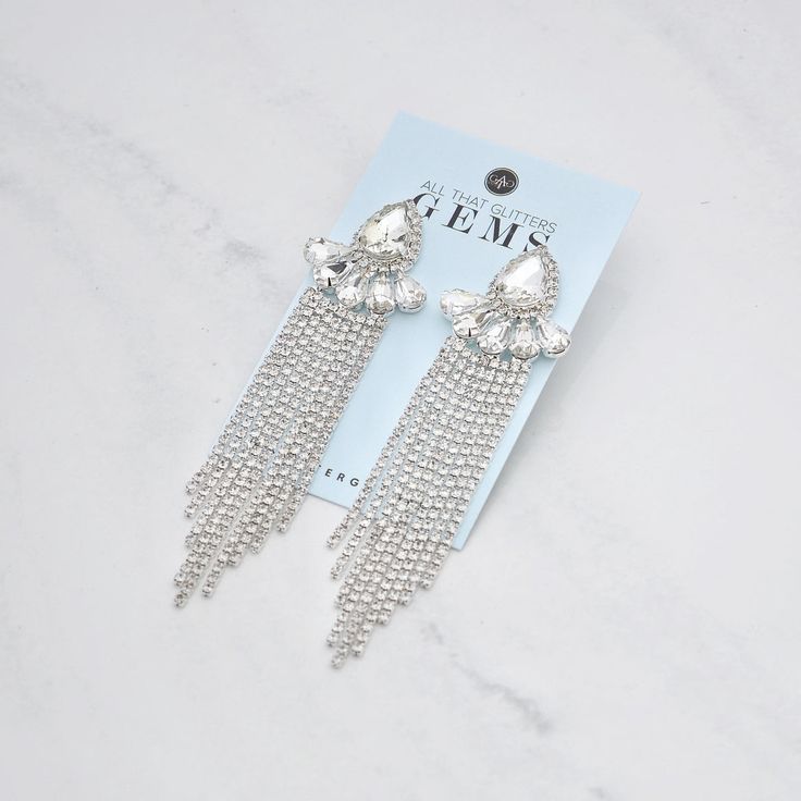 Sparkle in style with these J'adore -Clearncluster rhinestone dangle earrings, featuring a stunning clear rhinestones set on silver. Measuring 4" in length and 1" in width, these earrings are perfect for a fitness competitor looking for a versatile accessory. The stainless steel hypoallergenic post ensures comfort and security, while the cubic zirconia cluster vine fringe design adds a touch of elegance and glamour. Get ready to turn heads and feel confident with these must-have earrings! Glamorous Sparkling Diamond White Chandelier Earrings, Glamorous Sterling Silver Chandelier Earrings With Sparkling Stones, Silver Diamond Chandelier Earrings With Dangle, Glamorous Sterling Silver Bridal Earrings, Silver Cubic Zirconia Chandelier Earrings For Party, Dangle Jewelry With Rhinestone Fringe In Crystal, Crystal Dangle Jewelry With Rhinestone Fringe, Glamorous Silver Chandelier Earrings With Cubic Zirconia, Silver Crystal Chandelier Earrings For Party