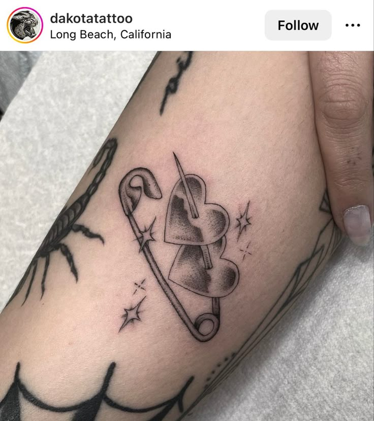 a person with a tattoo on their arm holding up a knife and heart shaped object