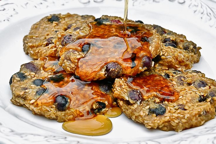 a white plate topped with oatmeal and fruit covered cookies