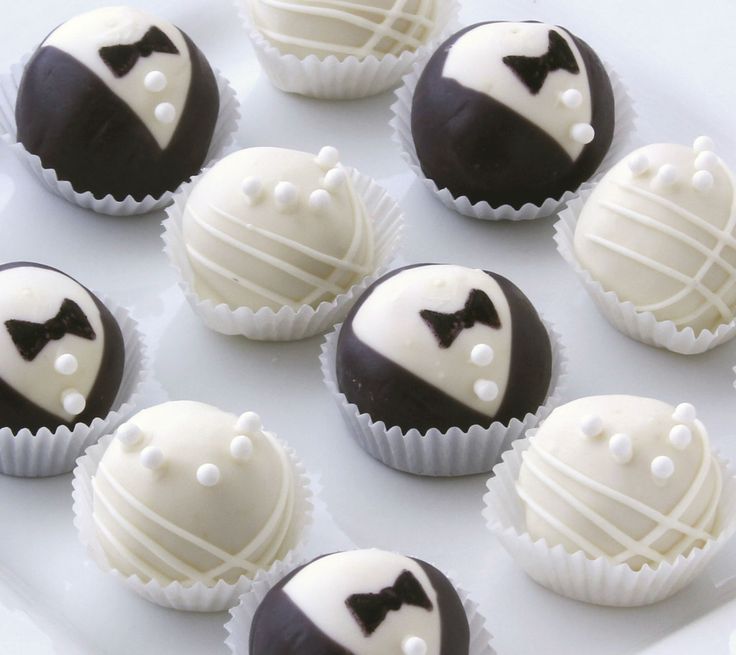 chocolates with white frosting and black bow ties on them