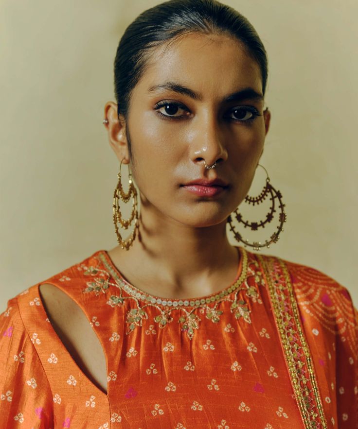 The rust printed, hand-embroidered kurta in dupion silk paired with printed flared pants and a tasseled dupatta sounds like a striking ensemble. The hand embroidery adds intricate detailing to the kurta, while the printed pants and dupatta complement the overall look with their coordinated design. Bollywood Style Tussar Silk Palazzo Set With Resham Embroidery, Navratri Tussar Silk Sharara With Dabka Work, Festive Slub Silk Palazzo Set With Gota Work, Orange Chanderi Palazzo Set With Gota Work, Anarkali Tussar Silk Palazzo Set, Festive Cotton Silk Palazzo Set With Traditional Drape, Designer Anarkali Tussar Silk Palazzo Set, Festive Tussar Silk Anarkali Set With Dabka Work, Diwali Tussar Silk Palazzo Set With Zari Work