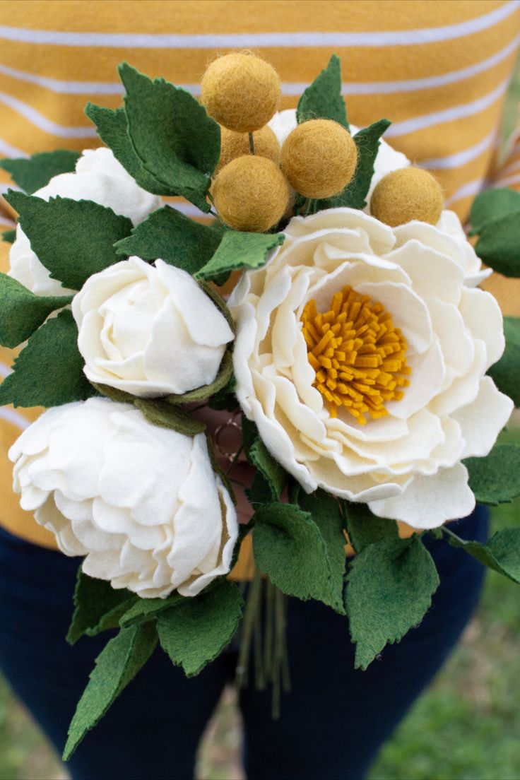 a woman holding a bouquet of flowers in her hands