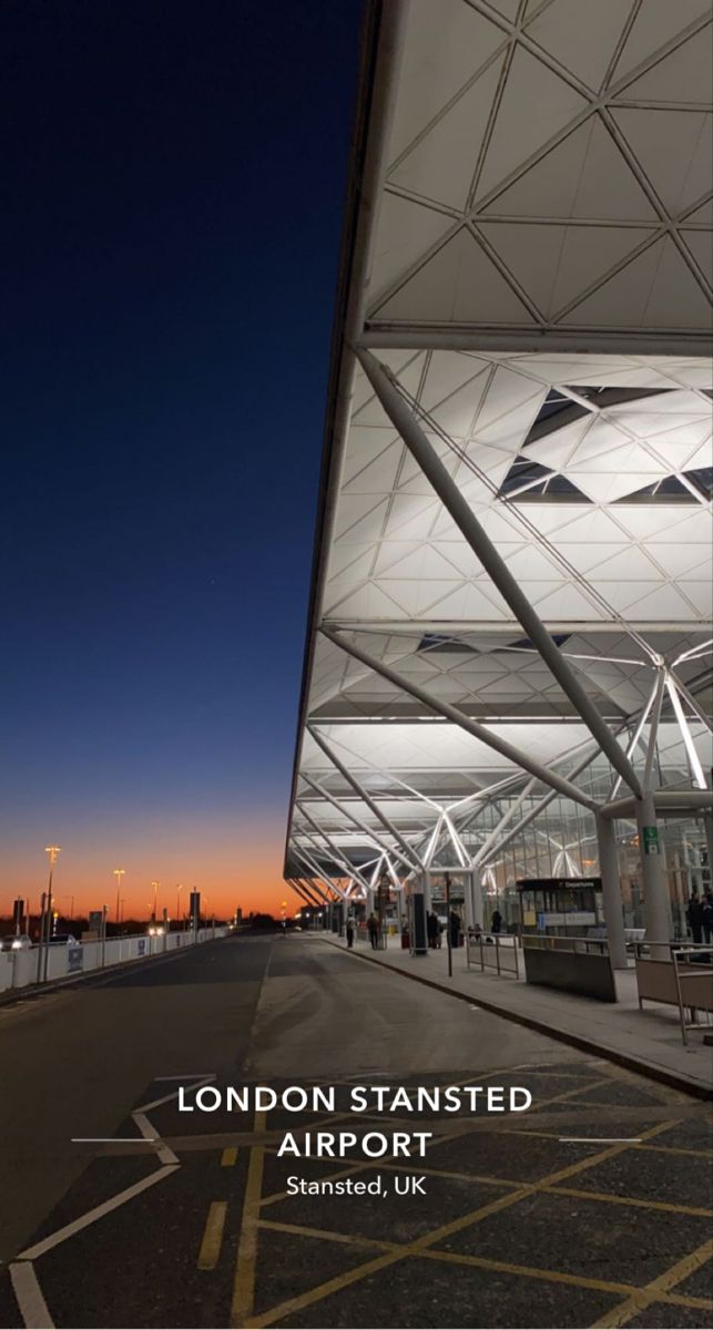 an airport terminal with the sun setting in the background