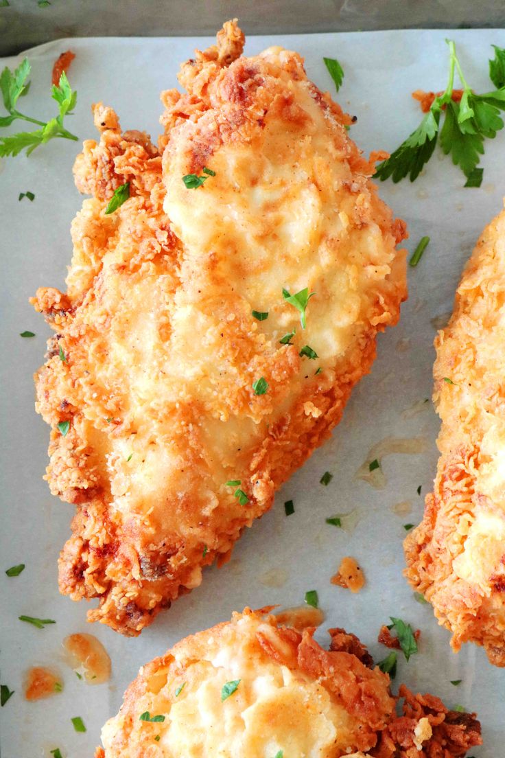 fried chicken with parmesan cheese and parsley sprinkled on the side