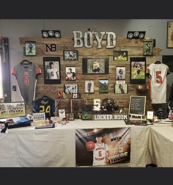 a table topped with pictures and memorabilia next to a wall covered in sports memorabilias