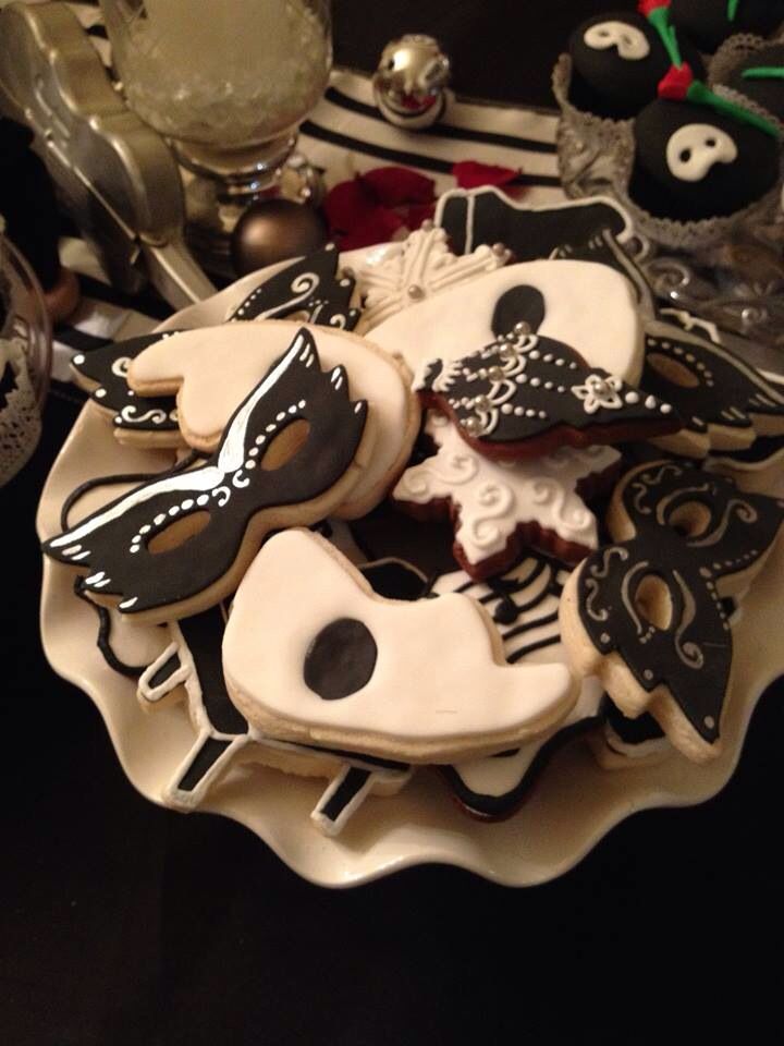 some decorated cookies are on a plate with silverware and other decorations in the background