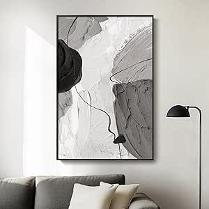 a black and white abstract painting hangs on the wall above a couch in a living room