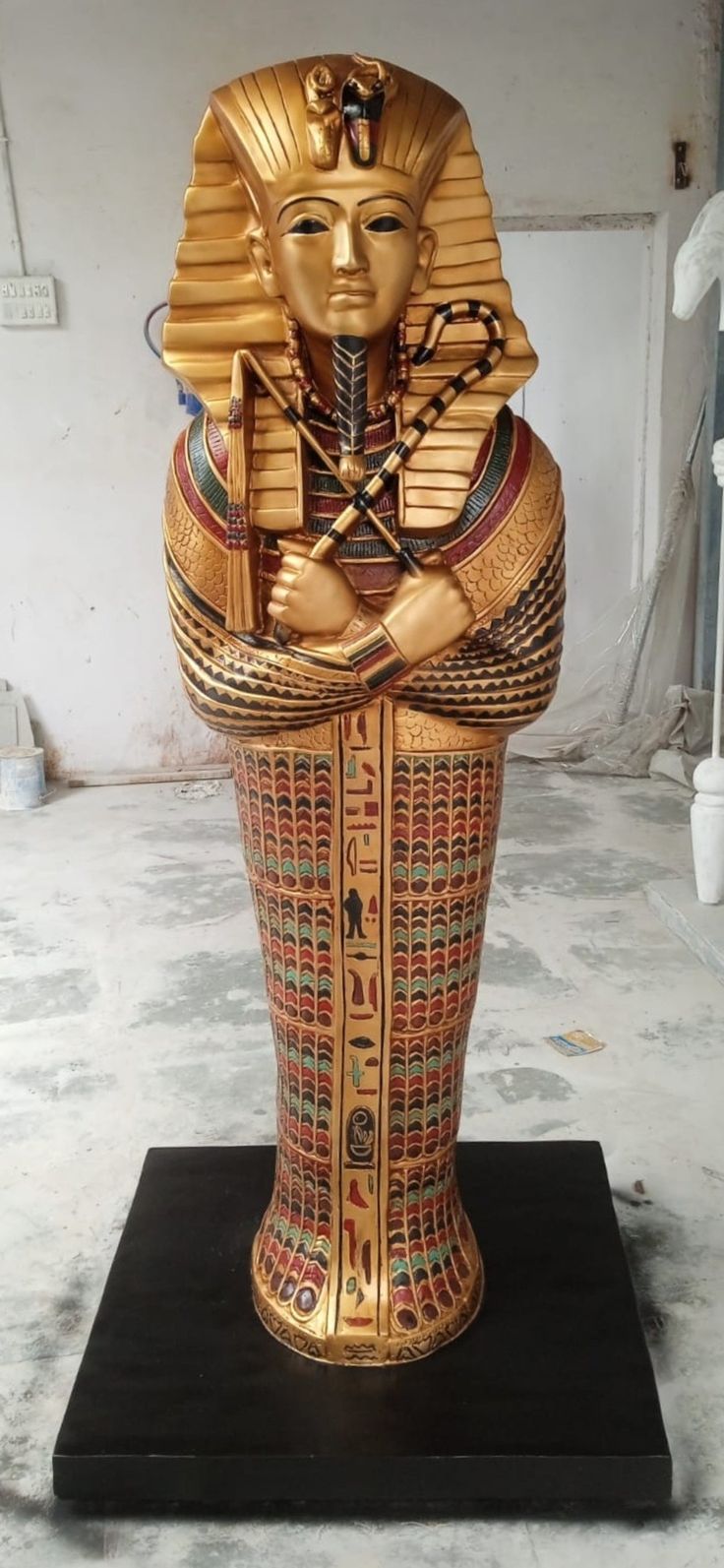 an egyptian statue sitting on top of a black stand