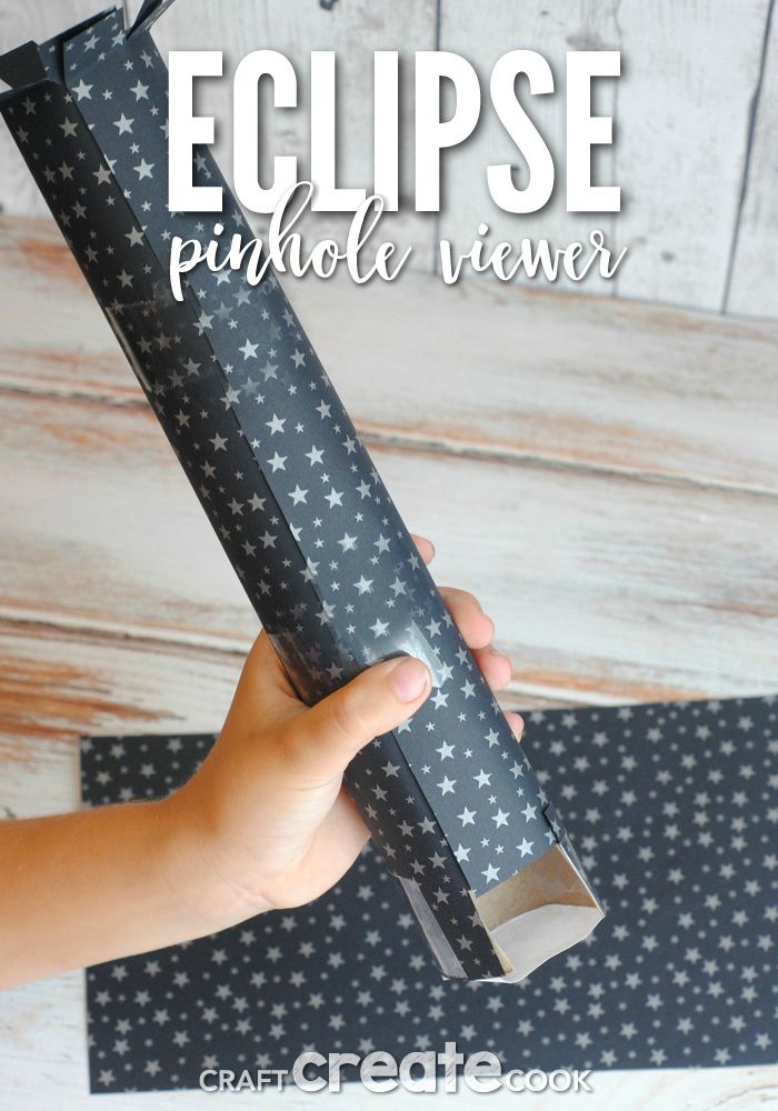 a hand holding a black wrapping paper with white stars on it and the words eclipse printed in