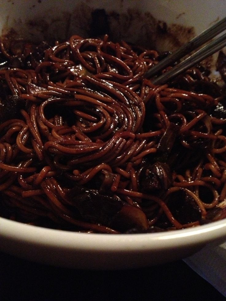 a white bowl filled with noodles and meat