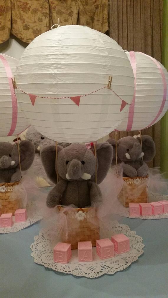 some stuffed animals are on display in front of paper lanterns and other decorations for a baby shower