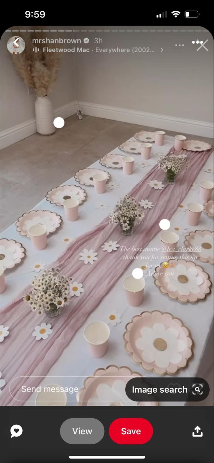 the table is set up with pink and white plates, cups, and vases