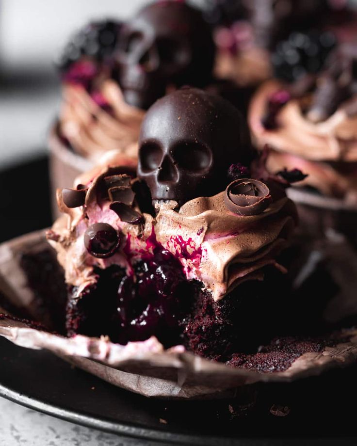 a chocolate cupcake with frosting and skulls on top