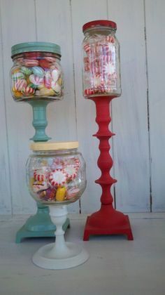 three jars filled with candy sitting next to each other on top of a white table