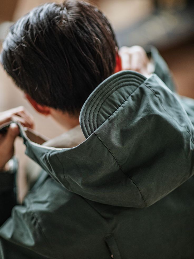 a man in a green jacket looking at his cell phone