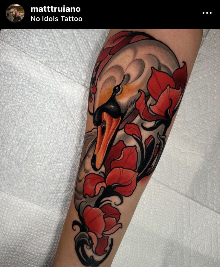 a bird with red flowers on it's arm is shown in this tattoo design