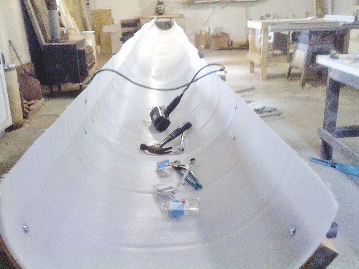 a boat is being worked on in a shop with tools and other items around it