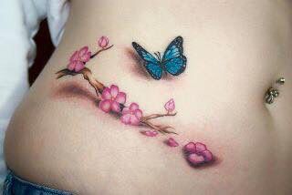 a woman's stomach with pink flowers and a blue butterfly on the top of it