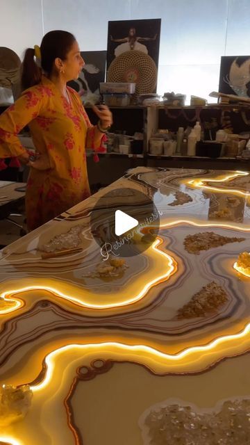 a woman standing in front of a table covered in yellow and white marbled items