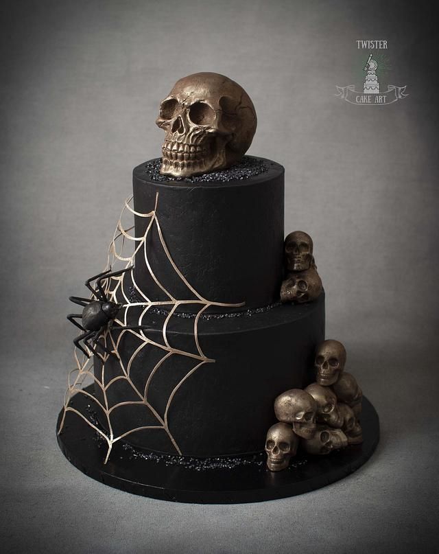 a three tiered cake decorated with skulls and spider webs